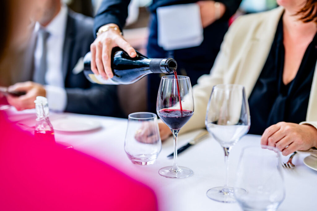 Main d'une étudiante de l'EHG servant un vin au restaurant Vieux Bois à Genève.