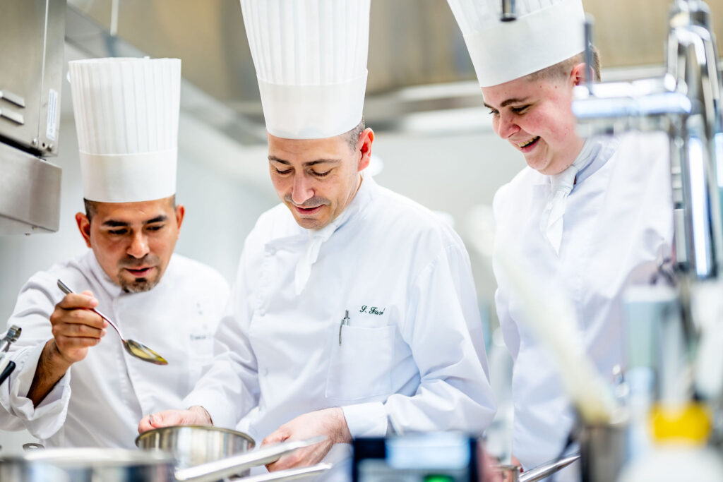 Chef et étudiants de l'EHG en cuisine au Vieux Bois, préparation d'une sauce professionnelle à Genève.